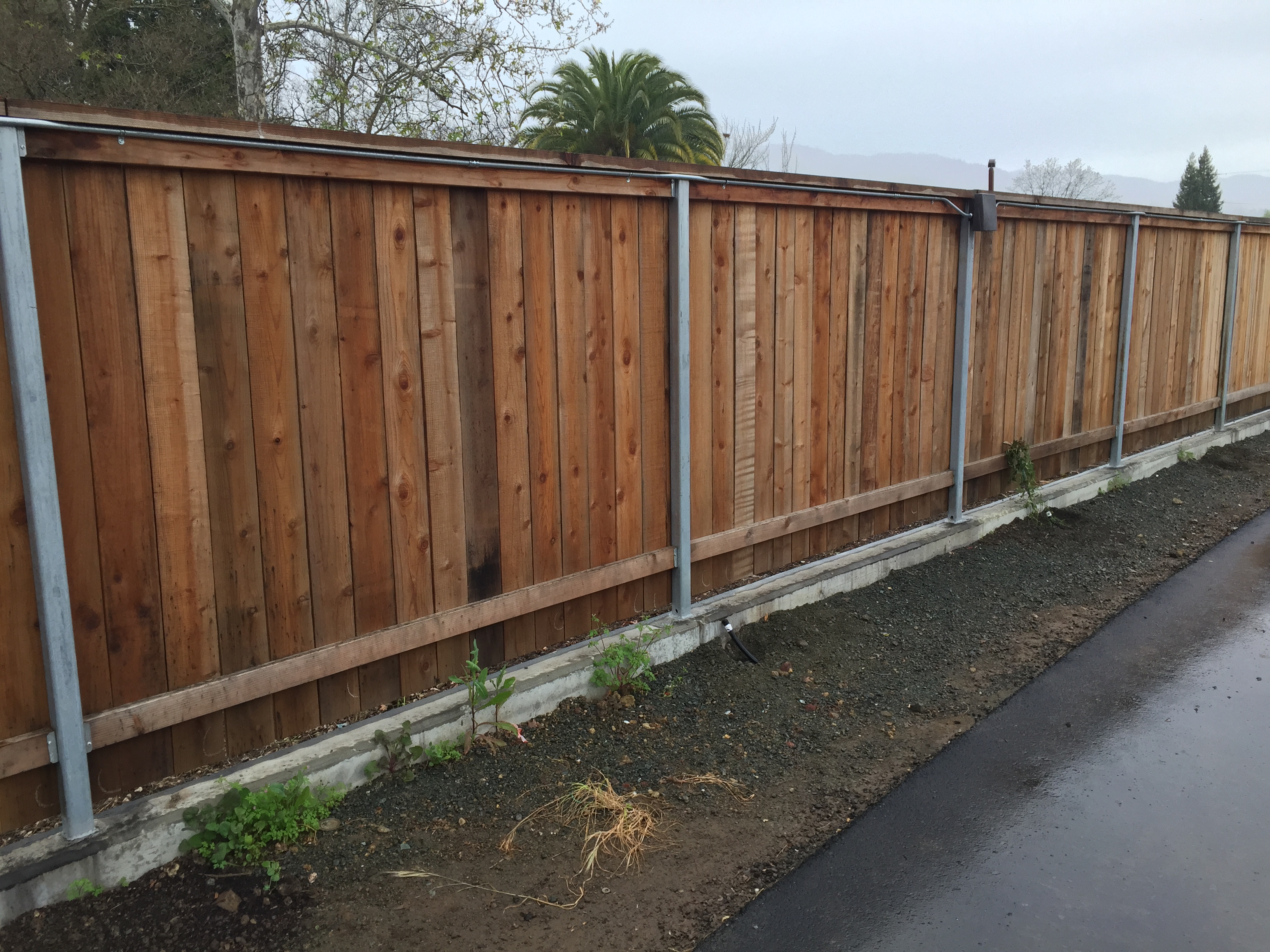 Wood Fence on Retaining Wall - Coggins Fence